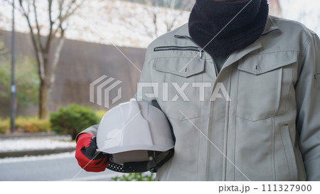 ネックウォーマーで防寒対策をする作業服の男性と積雪風景 ネックウォーマーで防寒対策をする作業服の男性と積雪風景 111327900