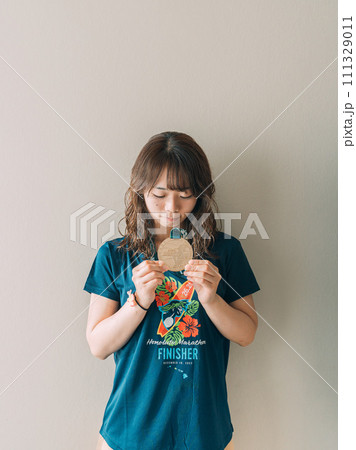 完走メダルを持つ女性 111329011