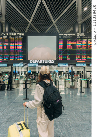 空港でスーツケースを持って旅行する女性 111329420