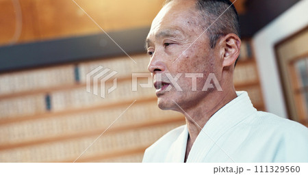 Master, karate or Asian man in dojo for martial arts for fitness, discipline or self defense for honor. Training, workout or senior kung fu professional talking for fighting, teaching or sports class 111329560