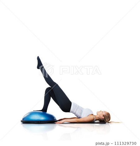 Floor, ball or athlete stretching legs in body workout for core development isolated on white background. Woman, exercise equipment or fitness for studio mockup space, balance challenge or wellness 111329730