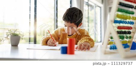 Student, drawing or child writing homework on notebook in kindergarten education for growth development. Project, creative boy or kid artist with color pencil learning or working on sketching skills 111329737