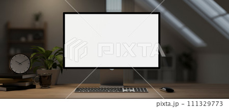 A computer desk with a computer mockup and accessories on a hardwood table in a room. 111329773