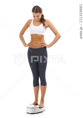 Studio, happiness and woman check scale machine to track weight loss, exercise results or body transformation. Satisfaction, slim and model smile for mass, BMI or diet progress on white background Studio, happiness and woman check scale machine to track weight loss, exercise results or body transformation. Satisfaction, slim and model smile for mass, BMI or diet progress on white background 111329881