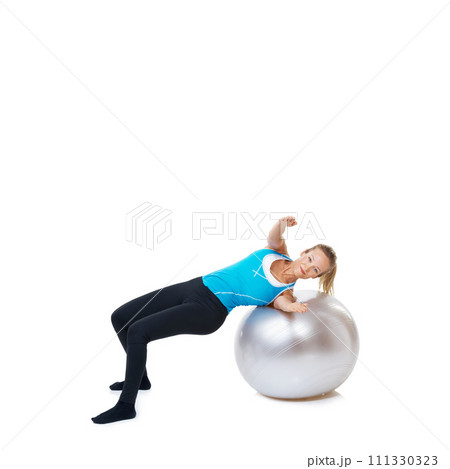 Portrait, fitness and happy woman stretching on an exercise ball in studio on white background. Gym, mockup and female person with inflatable for flexibility, training or balance, sports or workout Portrait, fitness and happy woman stretching on an exercise ball in studio on white background. Gym, mockup and female person with inflatable for flexibility, training or balance, sports or workout 111330323