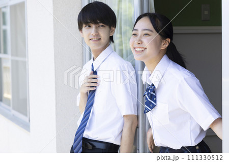 学校の廊下で話をする高校生 111330512