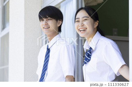 学校の廊下で話をする高校生 111330627