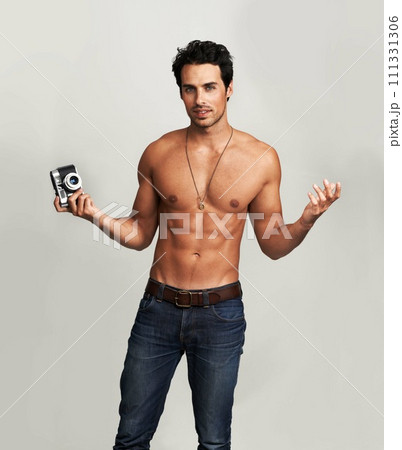 Camera, shirtless and portrait of man in a studio with art, creative and photography career. Confused, doubt and young male photographer from Canada with dslr equipment isolated by gray background. Camera, shirtless and portrait of man in a studio with art, creative and photography career. Confused, doubt and young male photographer from Canada with dslr equipment isolated by gray background. 111331306