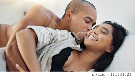 Happy couple, hug in bed and love with intimacy and romance at home for relationship, sex and bonding. Young people, woman and man relax in bedroom, cuddle and laughing with kiss and talking together 111331522