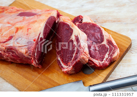 Pieces of raw boneless beef tenderloin on wooden background 111331957