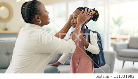 Getting ready, morning and a mother with a child for school, leaving kiss and talking in the living room. Happy, speaking and an African mom helping a girl with a backpack in a house for kindergarten 111331992