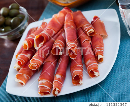 Rolled up slices of dry-cured ham 111332347