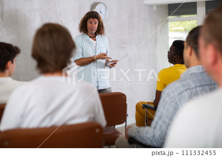Man lecturing to group of men gathered in study hall Man lecturing to group of men gathered in study hall 111332455