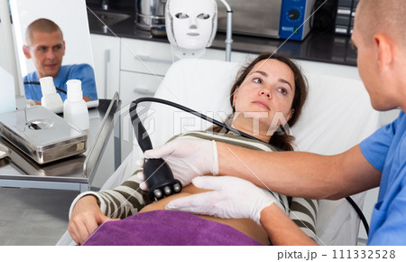 Woman getting ultrasound procedure for body contouring 111332528