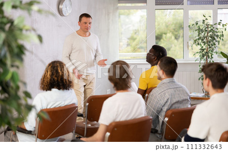 Man conducting educational class for male group in auditorium 111332643