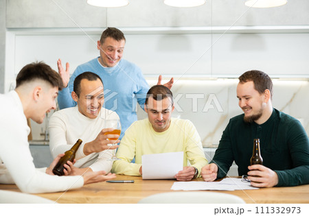 Happy man with friends celebrating new job offer at home Happy man with friends celebrating new job offer at home 111332973