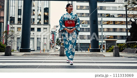 Woman, Japanese traditional clothes and walking in city, zebra crossing and travel with journey outdoor. Fashion, adventure and urban street in Kyoto, kimono or dress for culture and style with trip 111333069
