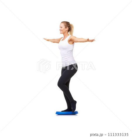 Balance, health and fitness with woman on disk in studio for workout, mindfulness or exercise. Wellness, challenge and training with person on white background for flexibility, smile or aerobics 111333135