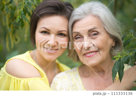 Beautiful elderly woman with her daughter walking in park 111333136