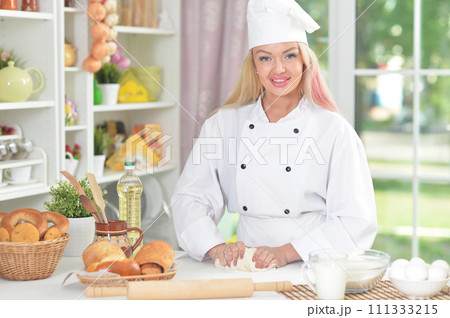 Beautiful young chief woman baking in kitchen Beautiful young chief woman baking in kitchen 111333215