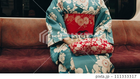 Person, japan or travel by train in kimono or locomotive transportation on metro bullet in city. Passenger, journey or traditional clothes in fast vehicle on weekend or commute in tokyo on adventure 111333317