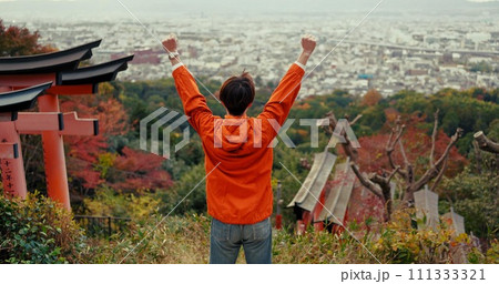 Man, fist celebration and mountain with view, city and torii gates at Fushimi Inari shrine for shinto religion. Person, hiking and cheers by trees, pillar or achievement on spiritual journey in Kyoto Man, fist celebration and mountain with view, city and torii gates at Fushimi Inari shrine for shinto religion. Person, hiking and cheers by trees, pillar or achievement on spiritual journey in Kyoto 111333321