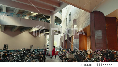 City, walking and woman in building with bicycle for travelling, commute and bike parking or station. Transport, urban town and Japanese person with storage for sustainable vehicles for journey City, walking and woman in building with bicycle for travelling, commute and bike parking or station. Transport, urban town and Japanese person with storage for sustainable vehicles for journey 111333341