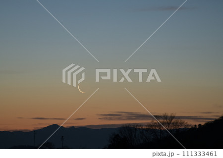 明け行く空に昇る月齢28.1の細い月 111333461