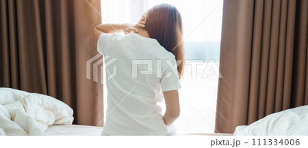 Woman having Neck and Shoulder pain during sitting on bed at home. Muscle painful due to Myofascial pain syndrome and Fibromyalgia, rheumatism, Scapular pain, Cervical Spine. Waking and Health concept 111334006