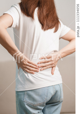 woman having back body ache during sitting on Couch at home. adult female with muscle pain due to Piriformis Syndrome, Low Back Pain and Spinal Compression. Office syndrome and medical concept woman having back body ache during sitting on Couch at home. adult female with muscle pain due to Piriformis Syndrome, Low Back Pain and Spinal Compression. Office syndrome and medical concept 111334056