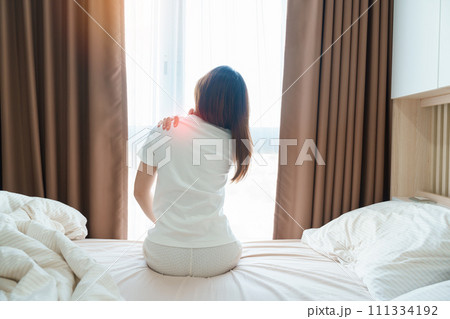 Woman having Shoulder and Neck pain during sitting on bed at home. Muscle painful due to Myofascial pain syndrome and Fibromyalgia, rheumatism, Scapular pain, Cervical Spine. Waking and Health concept Woman having Shoulder and Neck pain during sitting on bed at home. Muscle painful due to Myofascial pain syndrome and Fibromyalgia, rheumatism, Scapular pain, Cervical Spine. Waking and Health concept 111334192
