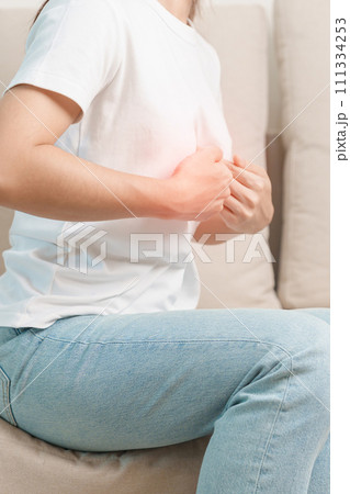 woman having abdomen ache due to Stomach pain, digestion with constipation or Diarrhea from food poisoning and liver cancer on the sofa at home 111334253