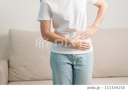 Woman having abdomen pain on the sofa at home. Liver cancer and Tumor, kidney cancer, Jaundice, Viral Hepatitis, Cirrhosis, Failure, Enlarged, Hepatic Encephalopathy, Stomach and health concept Woman having abdomen pain on the sofa at home. Liver cancer and Tumor, kidney cancer, Jaundice, Viral Hepatitis, Cirrhosis, Failure, Enlarged, Hepatic Encephalopathy, Stomach and health concept 111334258