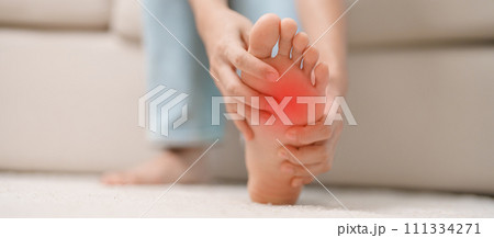 woman having barefoot pain during sitting on couch at home. Foot ache due to Plantar fasciitis and waking longtime. Health and medical concept 111334271