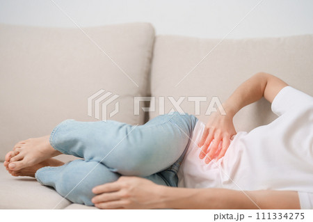 Woman having abdomen pain on the sofa at home. Liver cancer and Tumor, kidney cancer, Jaundice, Viral Hepatitis, Cirrhosis, Failure, Enlarged, Hepatic Encephalopathy, Stomach and health concept Woman having abdomen pain on the sofa at home. Liver cancer and Tumor, kidney cancer, Jaundice, Viral Hepatitis, Cirrhosis, Failure, Enlarged, Hepatic Encephalopathy, Stomach and health concept 111334275