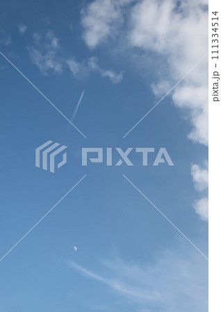 青空に月と飛行機雲 111334514