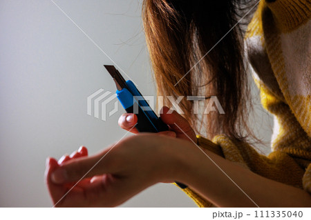 リストカットをする女性の手元のイメージ(顔なし) リストカットをする女性の手元のイメージ(顔なし) 111335040