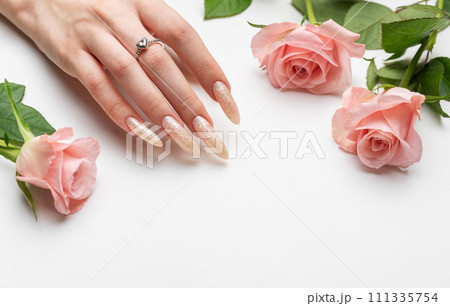 Female Hands on a white background with beautiful pearl manicure.Hands on a brown background and beautiful pearl manicure 111335754