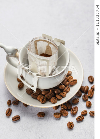 Drip coffee bag with ground coffee in cup Drip coffee bag with ground coffee in cup 111335764