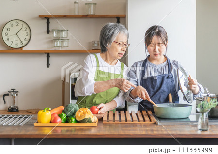 料理を見て文句を言う高齢者女性と泣く若い女性(嫁いびり) 料理を見て文句を言う高齢者女性と泣く若い女性(嫁いびり) 111335999