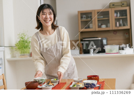 料理を配膳する女性・笑顔の主婦 111336269
