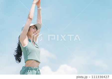 青空の中でストレッチをするアジア人女性(運動・スポーツ・ワークアウト・ボディメイク) 青空の中でストレッチをするアジア人女性(運動・スポーツ・ワークアウト・ボディメイク) 111336427