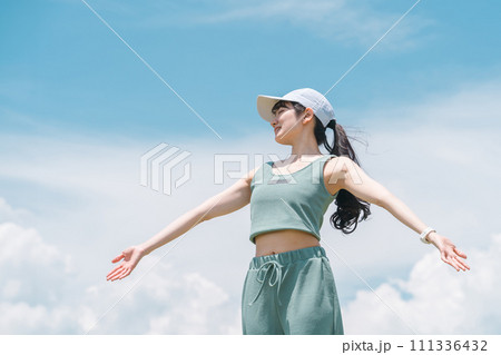 公園で深呼吸・ストレッチするスポーツウェアの女性（運動・スポーツ・トレーニング） 111336432