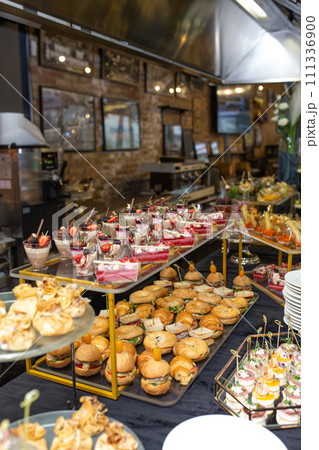 Catering banquet table with delicious food and snacks for party or corporate event Catering banquet table with delicious food and snacks for party or corporate event 111336900