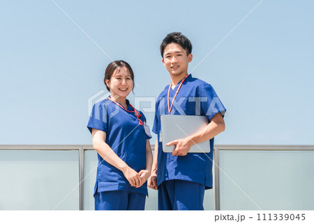 病院の屋上で話す医者・医師・看護師・医療従事者・ドクター・作業療法士・理学療法士の男女 病院の屋上で話す医者・医師・看護師・医療従事者・ドクター・作業療法士・理学療法士の男女 111339045
