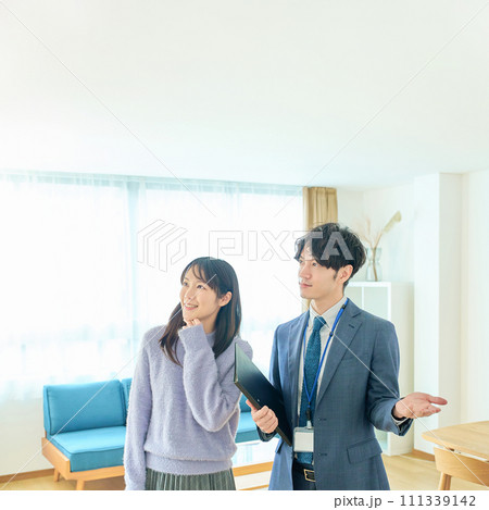 女性に部屋を説明するスーツ姿の男性 女性に部屋を説明するスーツ姿の男性 111339142