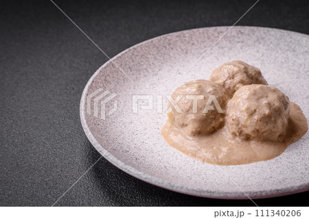Delicious meatballs from minced chicken or turkey with sour cream sauce 111340206
