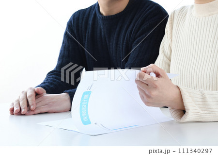 保険の資料を見て話し合う夫婦 保険の資料を見て話し合う夫婦 111340297