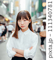 雑踏で立つ白いシャツの少女 111340781