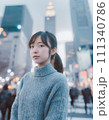 ビル街の雑踏で立つニットを着た女性 111340786